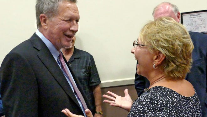 After speaking at the Americans for Peace Prosperity and Security South Carolina Chapter National Security Forum in Myrtle Beach, Republican presidential candidate, Ohio Gov. John Kasich got to share a laugh with Susan Mense of Myrtle Beach as she told him a story about her father asking Kasich and his boyhood friends not to play in his yard, Monday, Aug. 17, 2015.