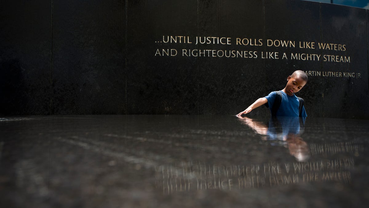 Benjamin Levett, 6, runs his hands through the Civil Rights Memorial fountain during a memorial to honor civil rights leader Julian Bond held by the Southern Poverty Law Center on Saturday, Aug. 22, 2015 in Montgomery, Ala.