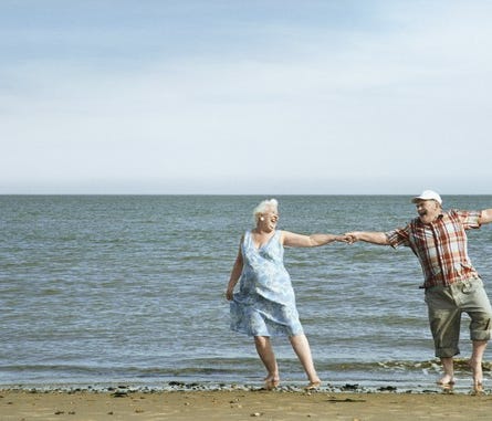 Smiling senior couple dancing on the beach