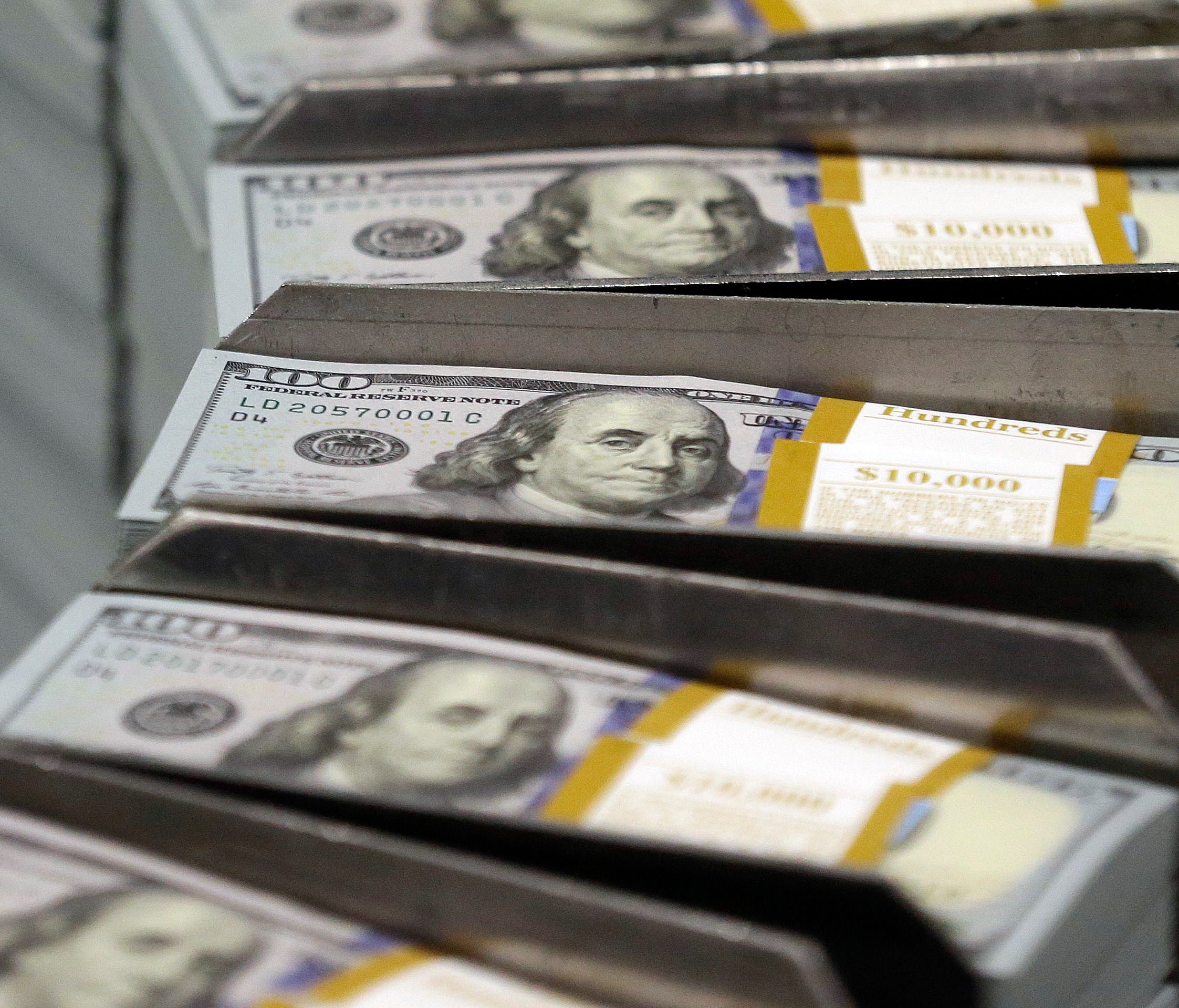 Bonus Cash: In this Sept. 24, 2013, file photo, just cut stacks of $100 bills make their way down the line at the Bureau of Engraving and Printing Western Currency Facility in Fort Worth, Texas.
