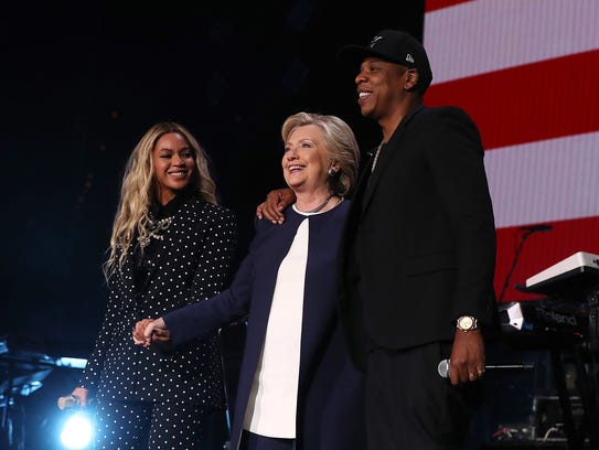 Beyonce, left, Hillary Clinton and JAY-Z appear on