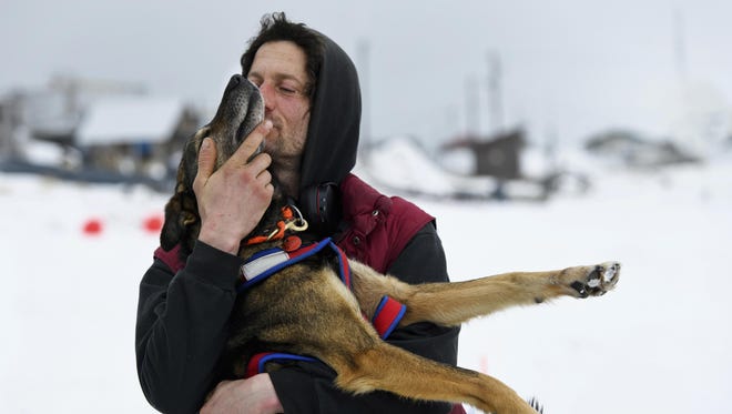 Nicolas Petit hugs one of his dogs before they leave Unalakleet, Alaska, during the Iditarod Trail Sled Dog Race on Sunday, March 10, 2019.