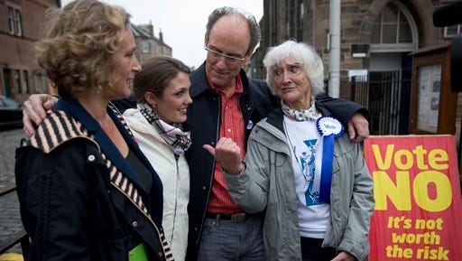 Scottish independence referendum Yes supporter 83-year-old Edinburgh resident Isabelle Smith, right, who lived in the U.S. for three decades, poses for a photograph with her family members, from left, her niece Lynn Wilson, 52, of Zurich, her granddaughter Jean Thomae, 23, of Washington DC, and her son John Smith, 52, of Atlanta, after an interview with The Associated Press outside a polling place in Edinburgh, Scotland, Thursday, Sept. 18, 2014.  Polls have opened across Scotland in a referendum that will decide whether the country leaves its 307-year-old union with England and becomes an independent state.  Smith's three children and seven grandchildren are all American, and several flew to Scotland for the referendum _ "to cocoon me in love," she said.  (AP Photo/Matt Dunham)