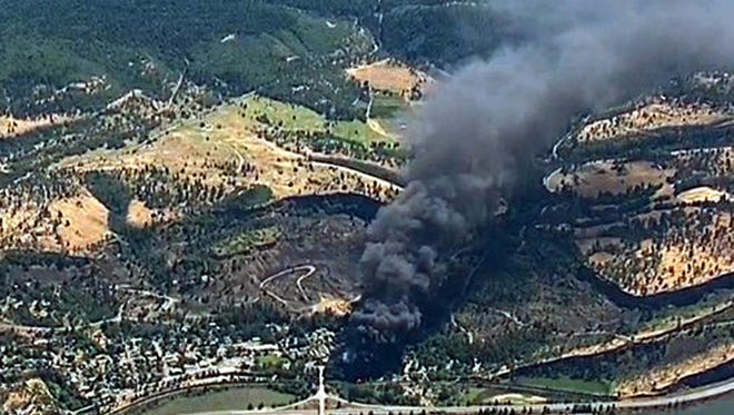 Smoke billows from a Union Pacific train that derailed near Mosier, Ore., in the scenic Columbia River Gorge. The Trump administration is angering environmental groups and residents of the Columbia River Gorge by rolling back a 2015 rule on oil train safety.