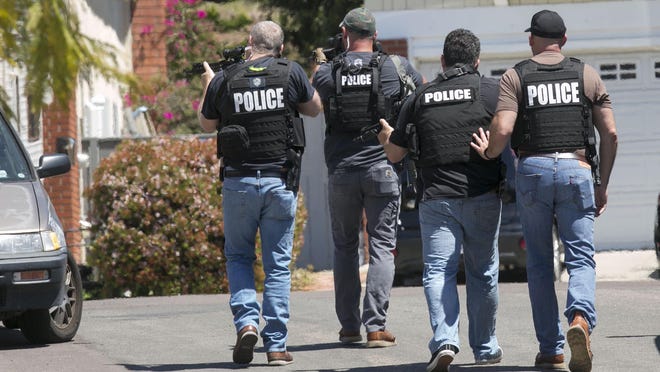 Heavily-armed San Diego police officers approach a house thought to be the home of 19 year-old John T. Earnest, who is a suspect in the shooting of four people in a Poway, Calif., synagogue, killing one, on Saturday, April 27, 2019, in San Diego. (John Gibbins/San Diego Union-Tribune/TNS)