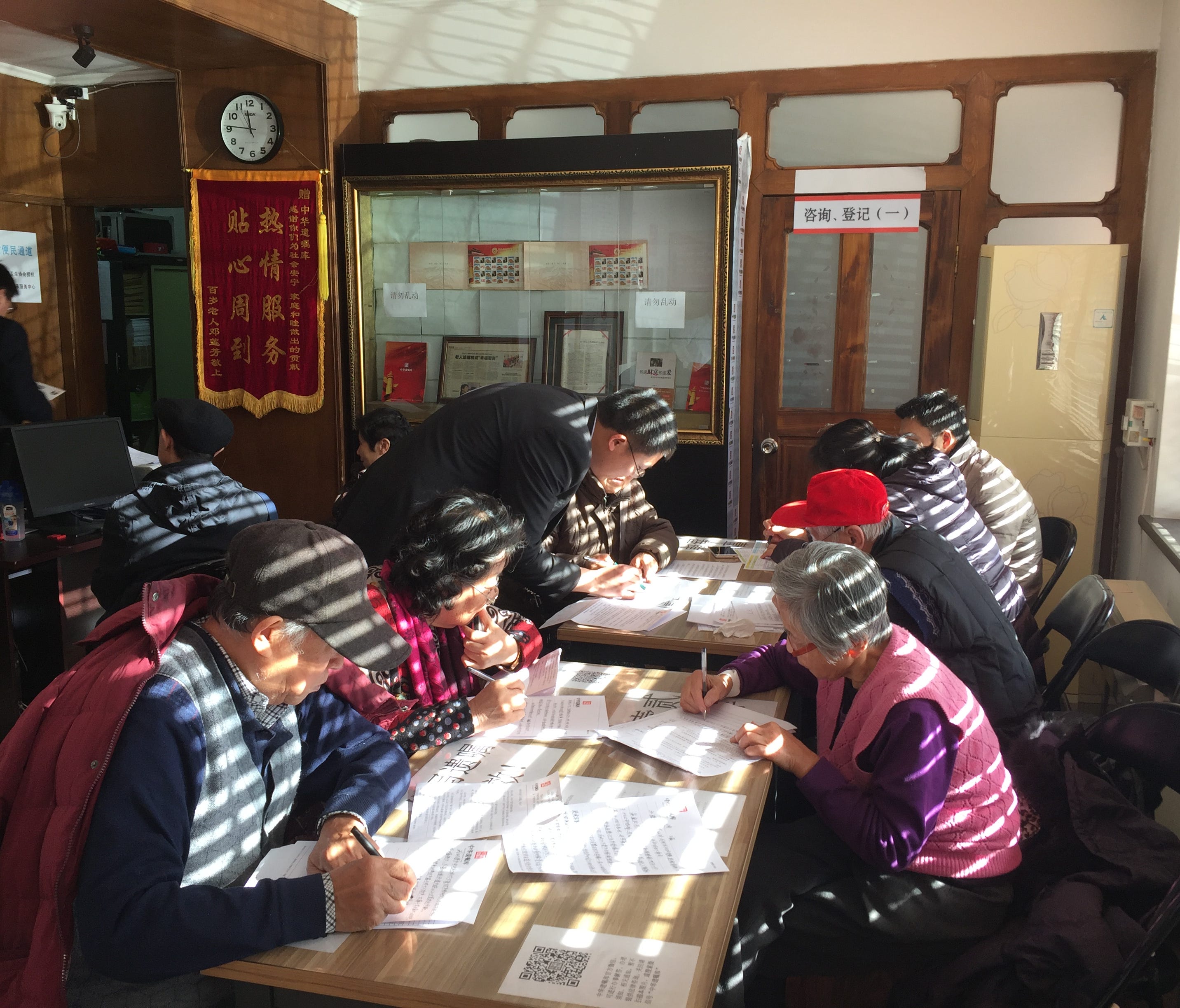 A group of senior citizens write their wills at a free legal center in Beijing.