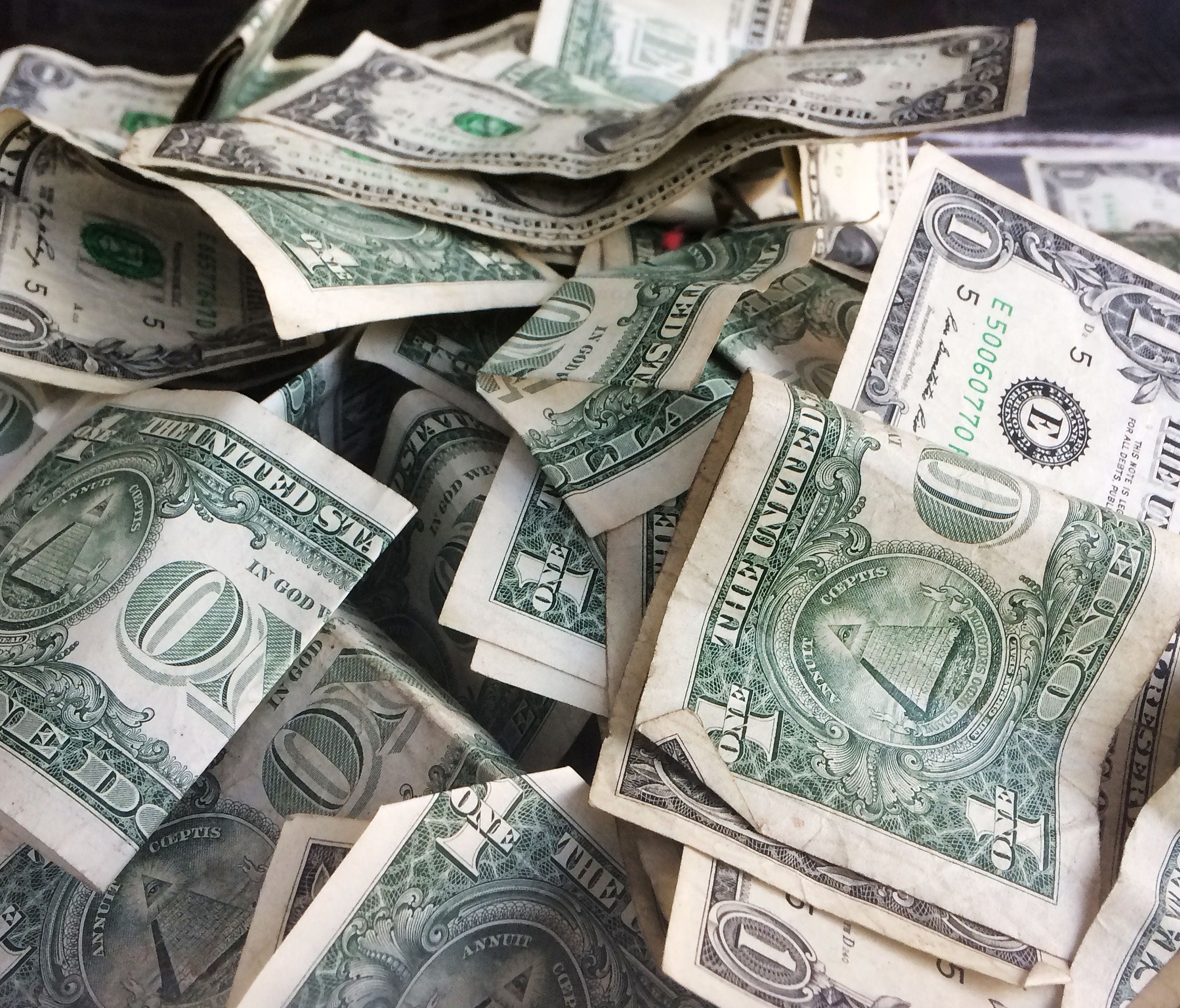 One dollar bills have been dropped into a tip jar at a car wash in Brooklyn, N.Y.