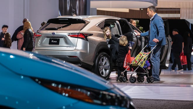 (right to left) Dale Wagnitz, of Royal Oak and his daughters Lily Wagnitz and Addison Wagnitz look over a Lexus NX 300h vehicle on Tuesday January 17, 2017 during the 2017 North American International Auto Show at Cobo Center in Detroit.