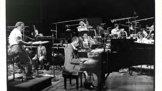 Manny Albam conducting the Arrangers’ Holiday Orchestra in 1980, with Hank Jones at the keyboard.