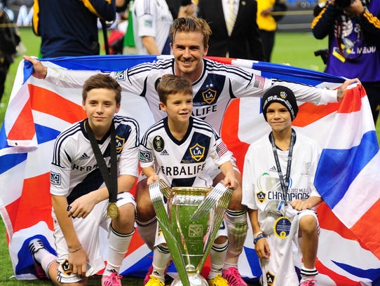 David Beckham poses with his sons Brooklyn, Cruz and