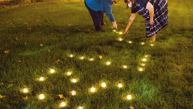 Tracy Owens, left, and Keri Tate light candles that spell out the initials BLM, short for Black Lives Matter, before a demonstration in front of the Springfield Police Department Wednesday, Sept. 23, 2020, to protest the decision of a Kentucky grand jury that brought no charges against Louisville police for the killing in March of Breonna Taylor during a drug raid gone wrong.