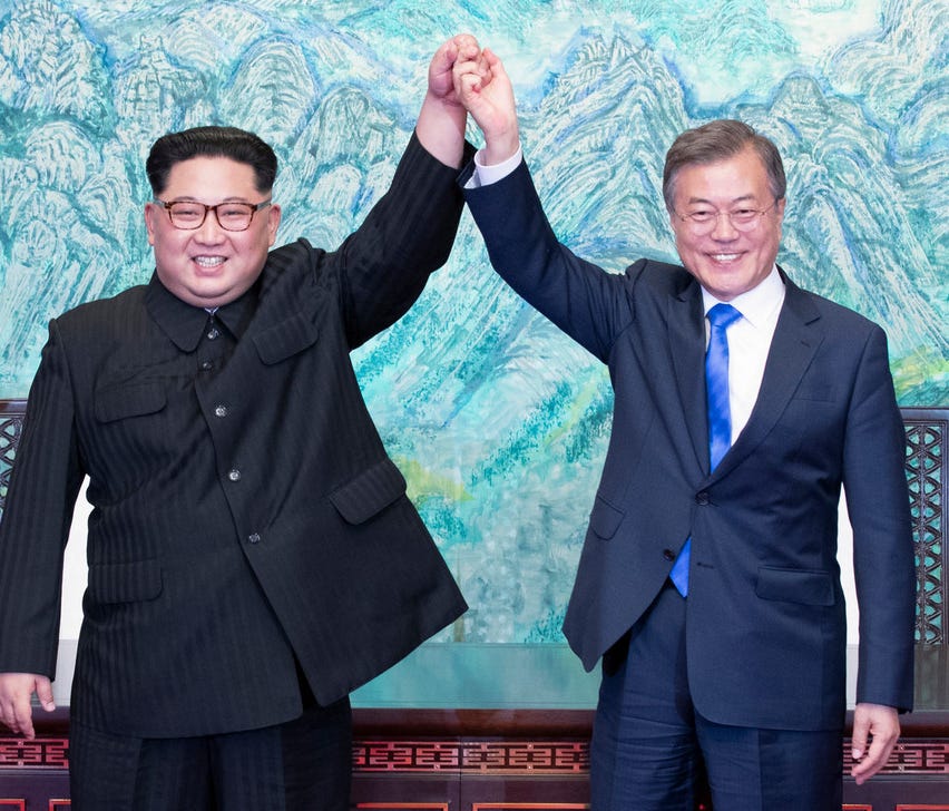 North Korean leader Kim Jong Un, left, and South Korean President Moon Jae-in raise their hands after signing a joint statement at the border village of Panmunjom in the the Demilitarized Zone, on April 27.