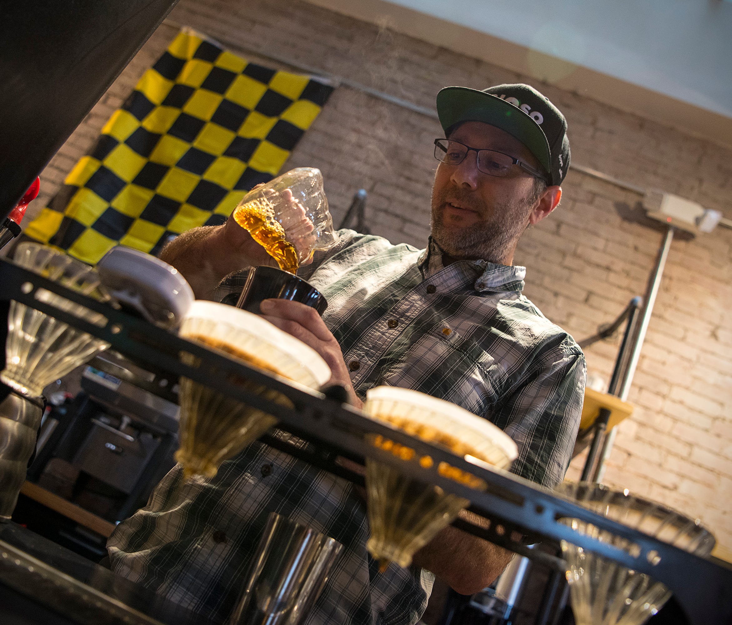 Cafe Brioso founder Jeff Davis prepares a mug of coffee at one of his downtown Columbus shops. Davis roasts beans from small co-ops and micro-lots in Costa Rica, Ethiopia, Guatemala, Brazil and Peru, offering various styles of pour-over coffee that c