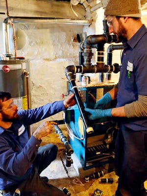 Jesse Haugh, left, and Anthony Zic, both of Shipley Energy, work fit pipe as they work to install an energy-efficient heating system in the home of Beverly Beatty, 66, of York City, Tuesday, Jan. 31, 2017. Shipley partnered with United Way in welcoming nominations over the holiday season, and Beatty was selected. Dawn J. Sagert photo