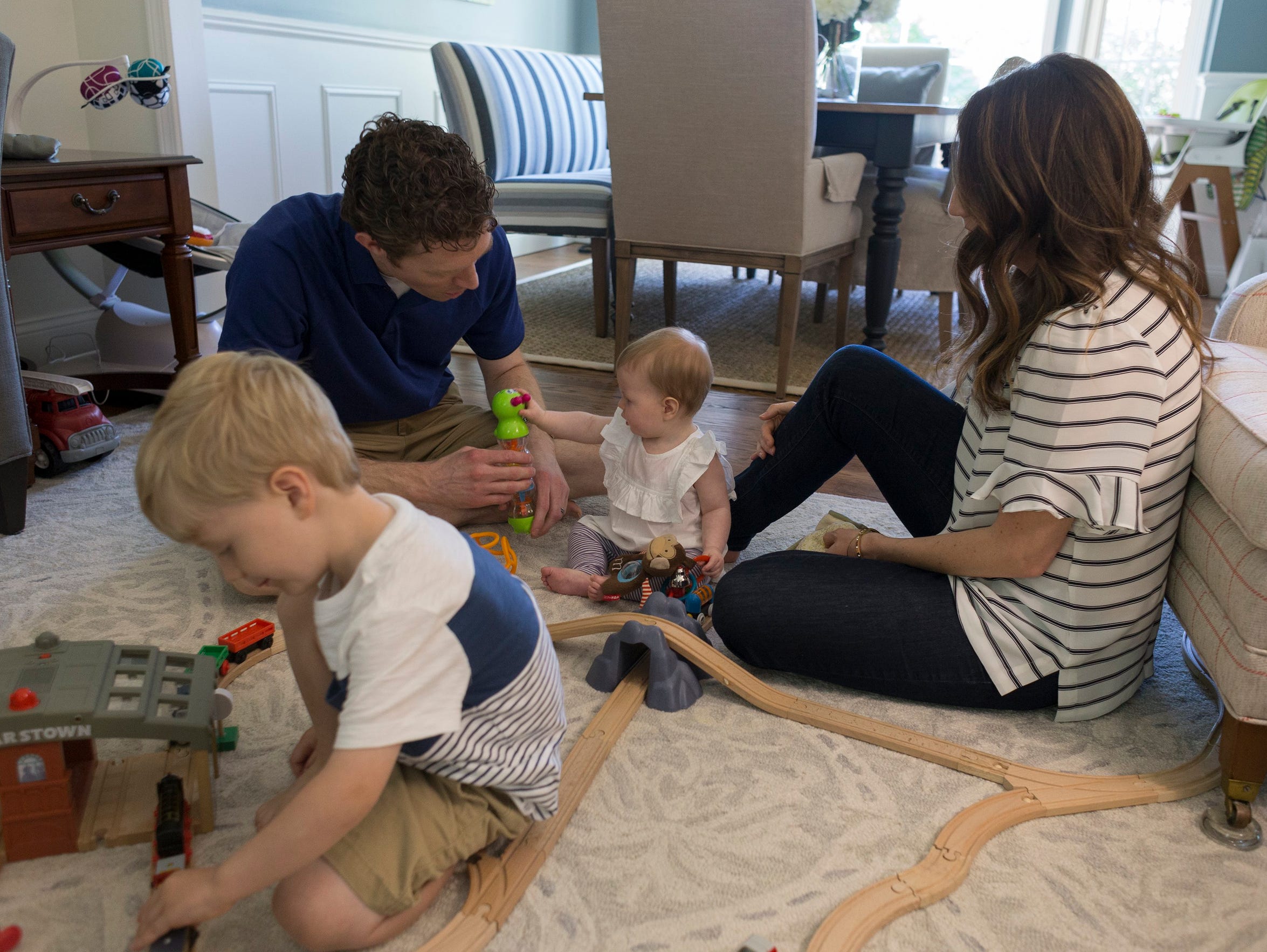 Phil Guster, left, plays with his 7-month-old daughter,