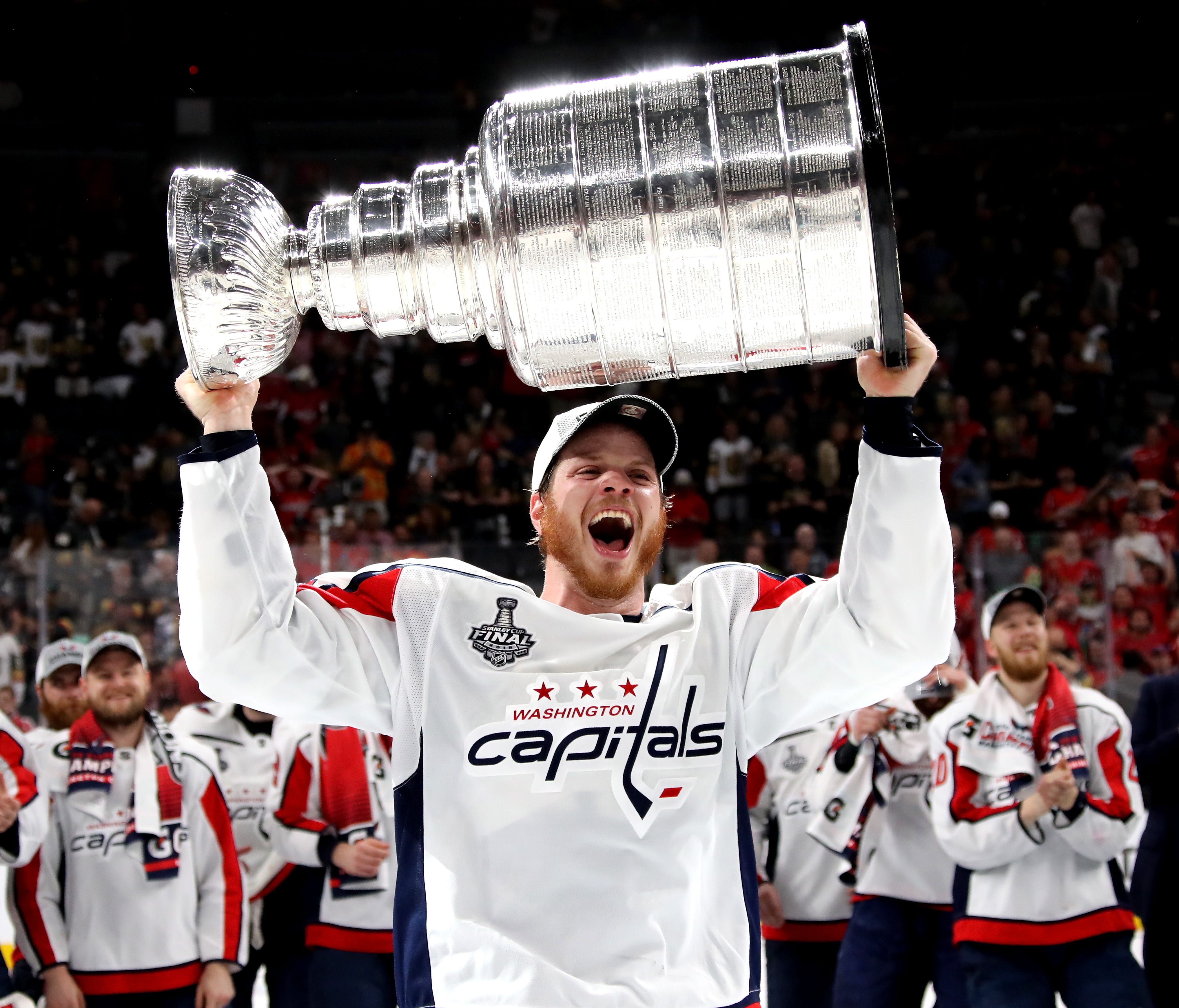 John Carlson hoists the Stanley Cup. Will he stay with the Capitals?