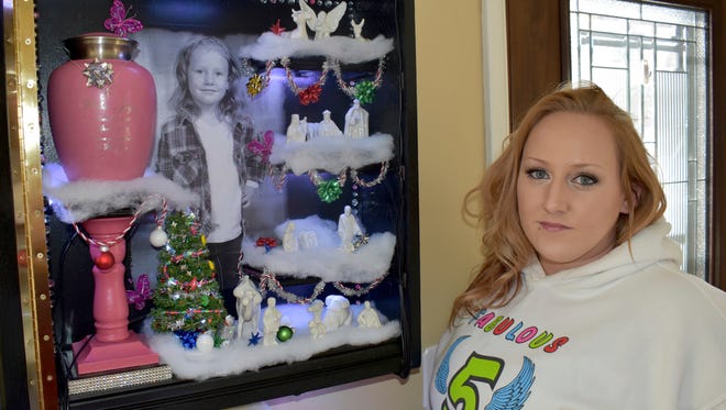 Shannon Huggett stands with a shadow box honoring her daughter, Phibie Joyce Moyer, who died with four others in an April 1 house fire in Spearfish, S.D. The Huggett family will honor Phibies memory this Christmas by buying gifts and clothes for a needy family. (Deb Holland/Black Hills Pioneer via AP)
