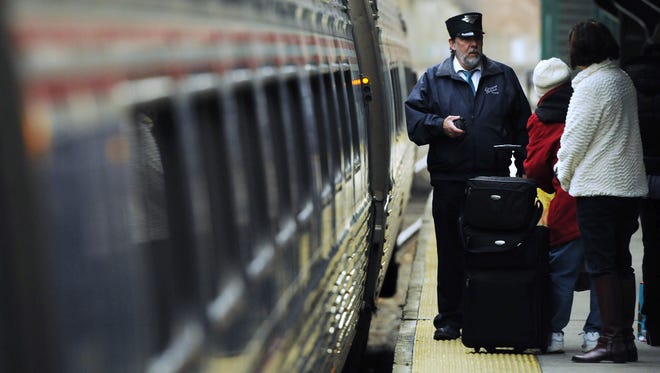 In this file photo, people board a north-bound Amtrak train at the Poughkeepsie Train Station.