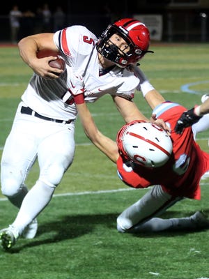 Oregon City's Connor Mitchell (5) is taken down by South Salem's Joseph Carey (6) in the Oregon City vs. South Salem class 6A playoffs football game at South Salem High School on Friday, Nov. 13, 2015. Oregon City won the game 49-21.