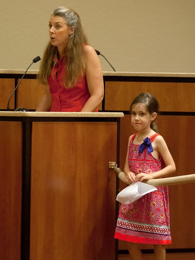 Coral Brennan, 7, listens to her mother, Tess Brennan, speak out against common Core testing Wednesday during a school board meeting at the Lee County Education Center in Fort Myers. Lee County is the first in Florida to opt out of Common Core testing.