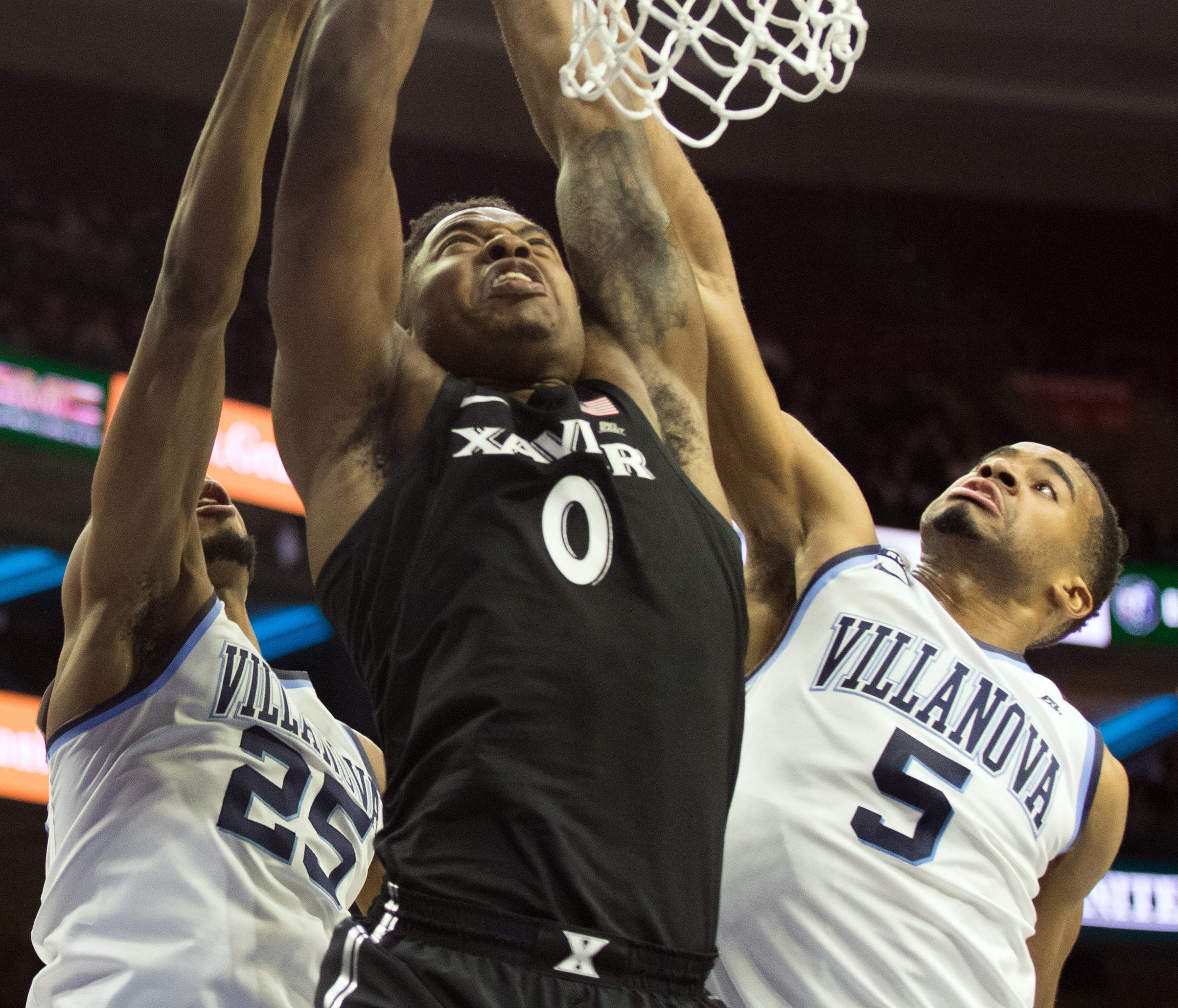 Xavier Musketeers forward Tyrique Jones (0) shoots against the defense of Villanova Wildcats guard Phil Booth (5) and guard Mikal Bridges (25) during the first half at Wells Fargo Center.