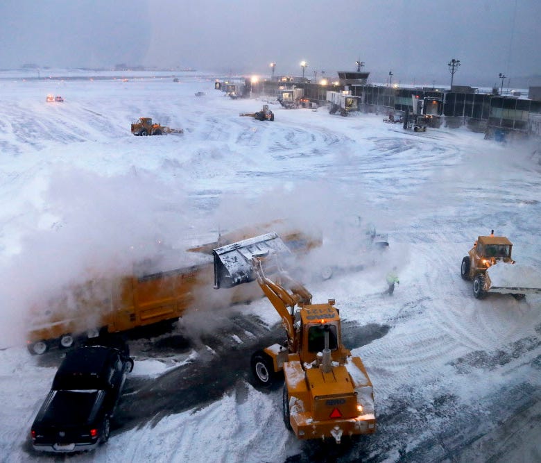 Front loaders dump snow into a melter while clearing the apron around Gates C and D at Terminal B at LaGuardia Airport on Jan. 4, 2018, in New York.
