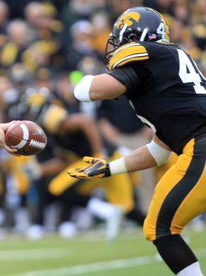 Iowa quarterback Jake Rudock hands the ball to Mark Weisman during their game against Wisconsin at Kinnick Stadium on Saturday, Nov. 22, 2014.