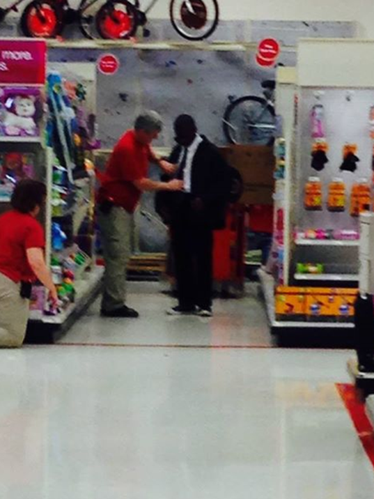 Target worker helps young man tie a tie for interview