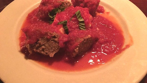 Tutto Italiano's "world’s best giant meatball" is cut into wedges and served with ricotta, marinara and fresh basil.