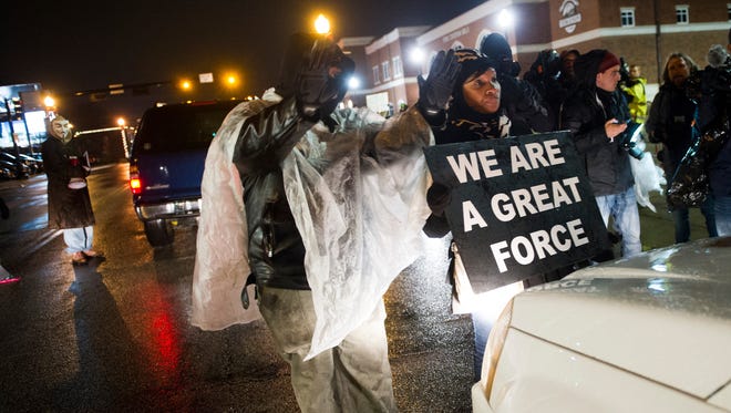 Protesters take to the street  and block traffic in front of the Ferguson Police Department on Friday, Nov. 21, 2014.