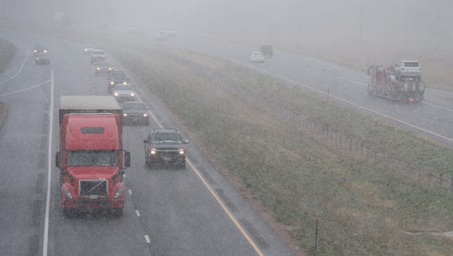 Traffic flows on I-25 as snow begins to fall near Timnath Thursday. Forecasts predict as much as eight inches of snow for the Northern Colorado area through Friday night.