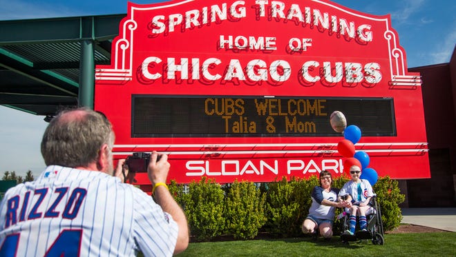 Fans pose for a photo outside Sloan Park in Mesa, home field for the Chicago Cubs during MLB spring traning.