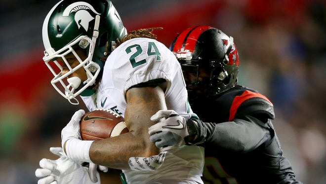 Michigan State running back Gerald Holmes carries the ball as Rutgers' Blessuan Austin defends Saturday at High Point Solutions Stadium in Piscataway, N.J.