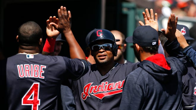 The Indians' Marlon Byrd gets high-fives in the dugout after scoring on a Tyler Naquin triple in the fourth inning Sunday.