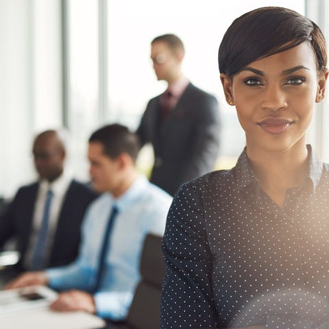 Smiling businesswoman with coworkers in background