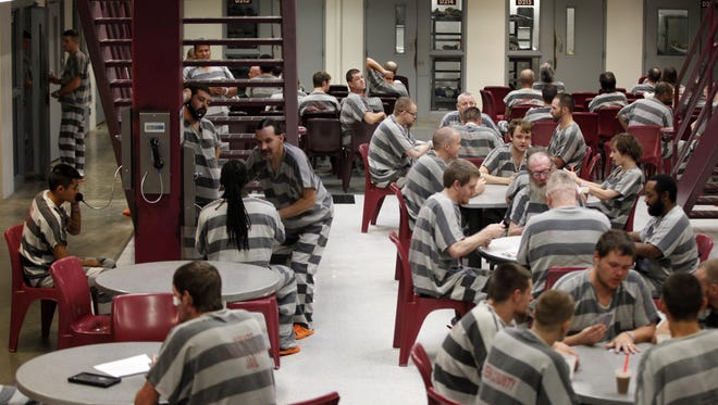 Inmates sit inside the D Pod of the Greene County Jail in July 2015.