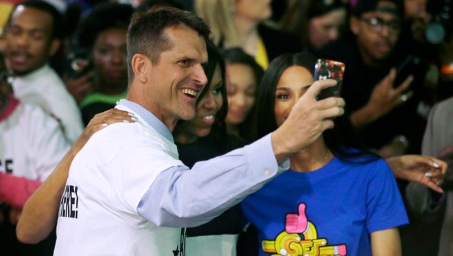 Michigan football coach Jim Harbaugh, left, takes a selfie with First Lady Michelle Obama, center, and Grammy Award winner Ciara on Friday, May 1, 2015, at Wayne State in Detroit.