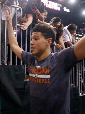Phoenix Suns' Devin Booker gets high-fives from Suns fans after an NBA basketball game against the Los Angeles Clippers Wednesday, April 13, 2016, in Phoenix.  The Suns defeated the Clippers 114-105. (AP Photo/Ross D. Franklin)