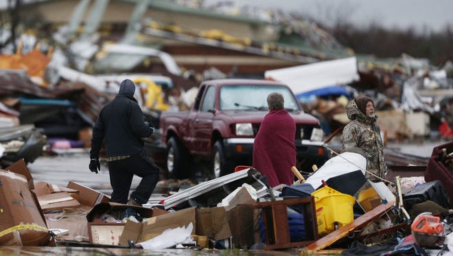 People assess damage Sunday to a storage facility destroyed by Saturday's tornado in Garland, Texas.