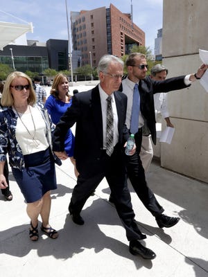 Former Arizona utility regulator Gary Pierce and his wife, Sherry, leave federal court after being arraigned on bribery and fraud charges.