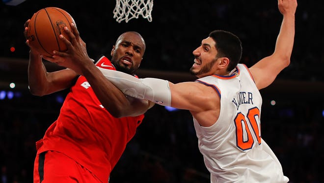 Toronto Raptors forward Serge Ibaka (9) and New York Knicks center Enes Kanter (00) battle for a rebound during the fourth quarter of an NBA basketball game, Wednesday, Nov. 22, 2017, in New York. The Knicks won 108-100. (AP Photo/Julie Jacobson)