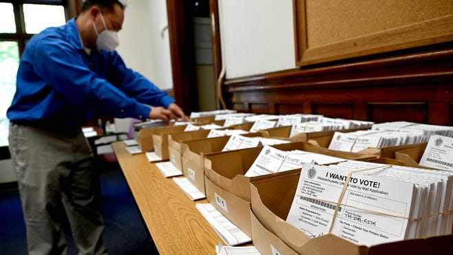 Marlborough Assistant City Clerk Wilson Chu looks at some of the vote-by-mail applications last October at Marlborough City Hall.