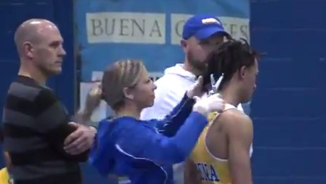 In this Dec. 19, 2018, file image taken from a video provided by SNJTODAY.COM, Buena Regional High School wrestler Andrew Johnson gets his hair cut courtside minutes before his match in Buena, N.J., after a referee told Johnson he would forfeit his bout if he didn't have his dreadlocks cut off. A lawyer for Johnson is suggesting the impromptu hair cut was due in part to the referee’s tardiness.
