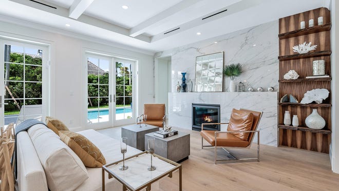 A marble fireplace with a built-in bookshelf anchors one end of the living area at 256 Fairview Road, a never-lived-in house on the market in Palm Beach for $6.795 million