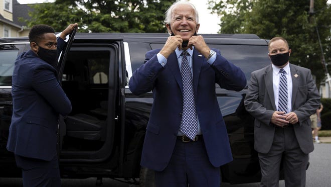 Democratic presidential candidate and former Vice President Joe Biden pulls down his mask as he makes an unannounced stop at his childhood home on North Washington Avenue in the Green Ridge section of Scranton, Pa., to visit the current homeowner, Anne Kearns, Thursday, July 9, 2020.