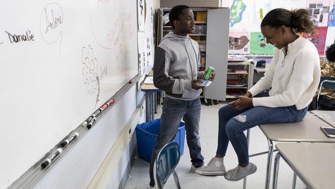 Student Joy Kunda, co-president of the Student Immigration Movement Club, left, speaks with student Rianna Lawrence during a club  meeting at Framingham High School in May 2019.