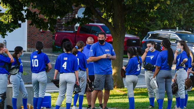 Danvers Girls Softball 14B coach Mark Romsavich talks to his players between innings during a Middle-Essex League game versus Melrose at Common Field in Melrose on Thursday, Aug. 6.
