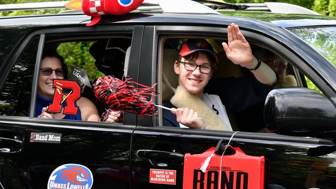 A Reading High School graduate waves to family and friends during a Spirit Parade for graduating high school seniors on May 23, 2020.