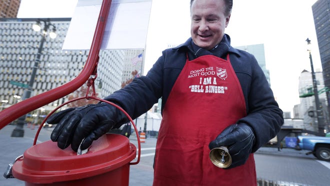 Dan Ponder, CEO of Franco Public Relations Group, places a donation in the kettle to kick off the 2014 Salvation Army Red Kettle fund-raising campaign in Cadillac Square on Nov. 7. The nonprofit organization is a Franco client.