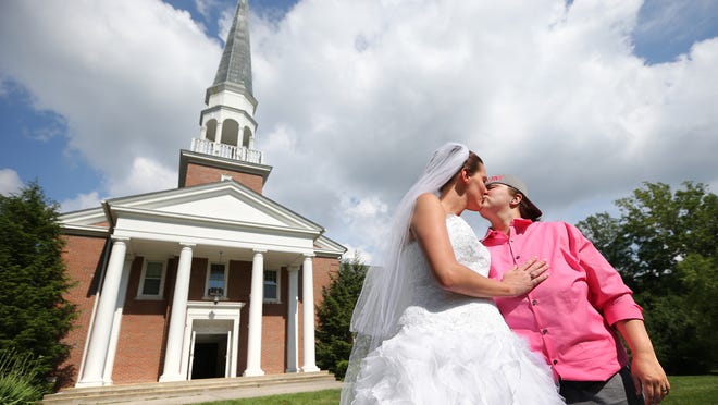 
Jennifer Snider and Mysti Brooks seal their ceremony with a kiss at the First Congregational United Church of Christ. 
